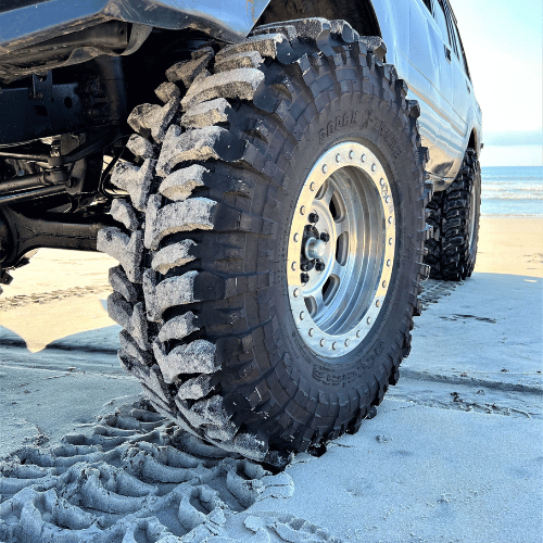 Tire Streets Accelera Badak X-Treme Ultra Aggressive Mud Terrain Tire close up at beach