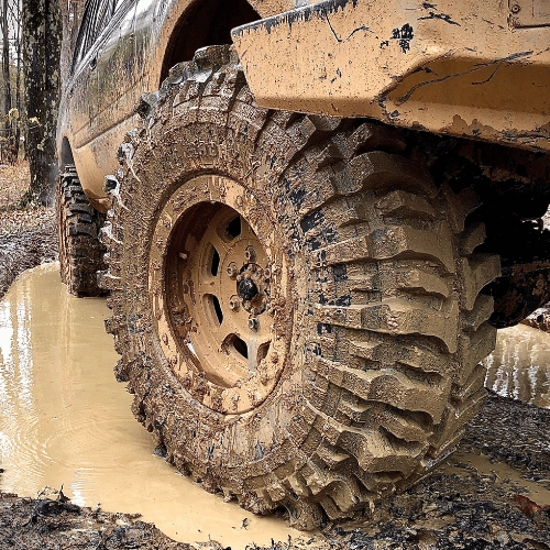 Tire Streets Accelera Badak X-Treme Ultra Aggressive Mud Terrain Tire in a mud puddle