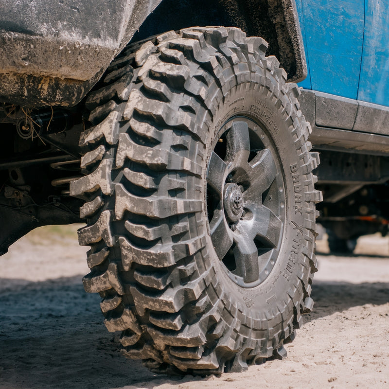 Close-up of an Accelera Badak X-Treme off-road tire mounted on a 4x4 vehicle, showing aggressive tread pattern for extreme terrain.