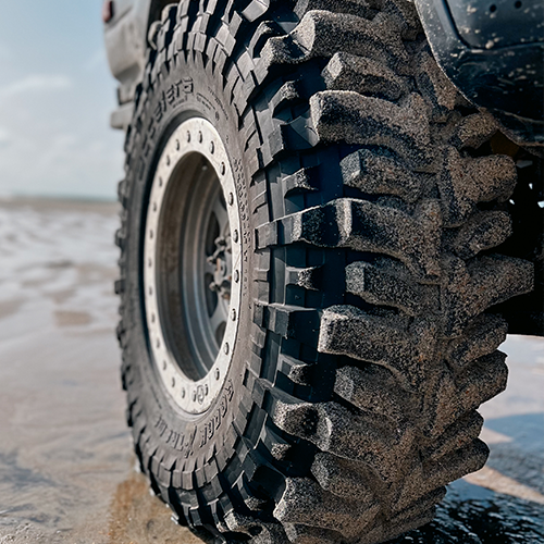 Tire Streets Accelera Badak X-Treme Ultra Aggressive Mud Terrain Tire close up at beach 